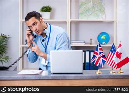 The young male travel agent working in the office. Young male travel agent working in the office