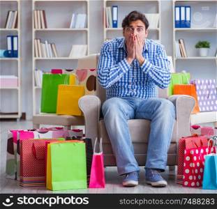 The young man after excessive shopping at home. Young man after excessive shopping at home