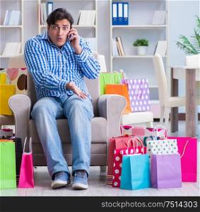 The young man after excessive shopping at home. Young man after excessive shopping at home