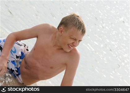 The young man bathes in the sea