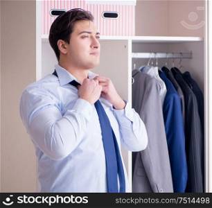 The young man businessman getting dressed for work. Young man businessman getting dressed for work