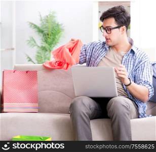 The young man buying clothing online and running blog. Young man buying clothing online and running blog