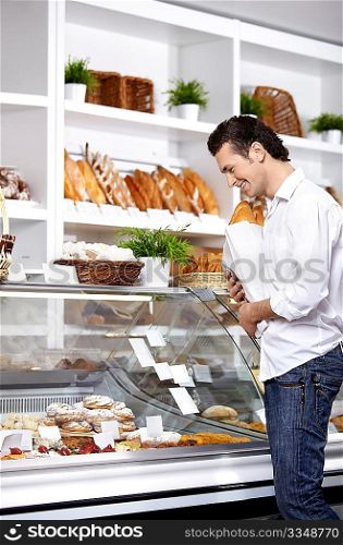 The young man buys bread in shop