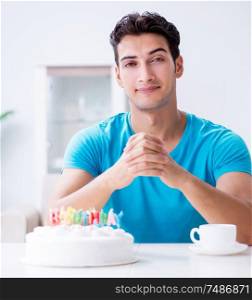 The young man celebrating birthday alone at home. Young man celebrating birthday alone at home