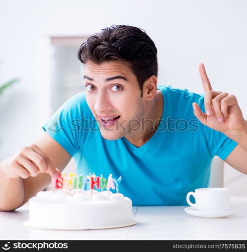 The young man celebrating birthday alone at home. Young man celebrating birthday alone at home