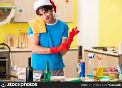 The young man cleaning kitchen after christmas party. Young man cleaning kitchen after Christmas party