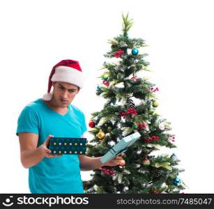 The young man decorating christmas tree isolated on white. Young man decorating christmas tree isolated on white