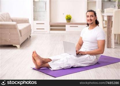 The young man doing physical exercises at home. Young man doing physical exercises at home