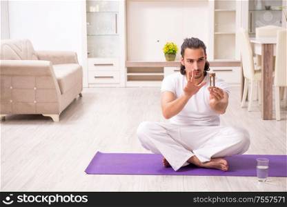 The young man doing physical exercises at home. Young man doing physical exercises at home