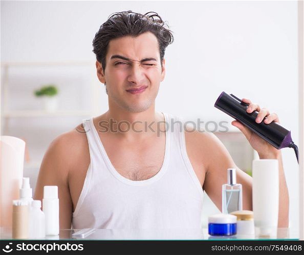 The young man drygin his hair in the morning. Young man drygin his hair in the morning