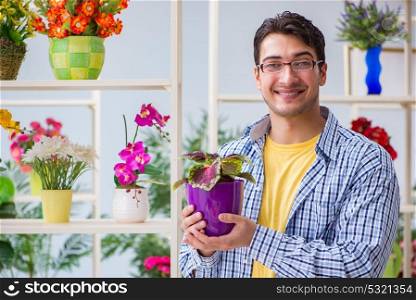 The young man florist working in a flower shop. Young man florist working in a flower shop