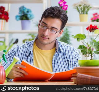 The young man florist working in a flower shop. Young man florist working in a flower shop