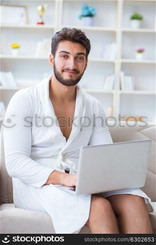 The young man freelancer working from home on a laptop. Young man freelancer working from home on a laptop