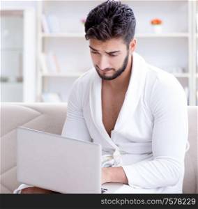 The young man freelancer working from home on a laptop. Young man freelancer working from home on a laptop