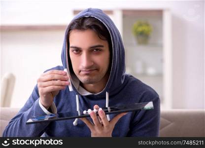 The young man having problems with narcotics at home. Young man having problems with narcotics at home