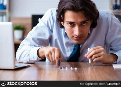 The young man having problems with narcotics at workplace . Young man having problems with narcotics at workplace 