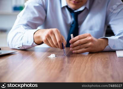 The young man having problems with narcotics at workplace . Young man having problems with narcotics at workplace