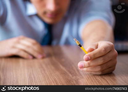 The young man having problems with narcotics at workplace. Young man having problems with narcotics at workplace