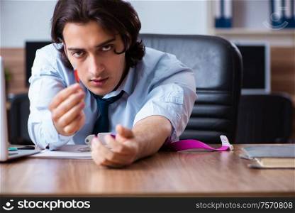The young man having problems with narcotics at workplace. Young man having problems with narcotics at workplace