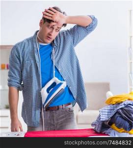 The young man husband doing clothing ironing at home. Young man husband doing clothing ironing at home
