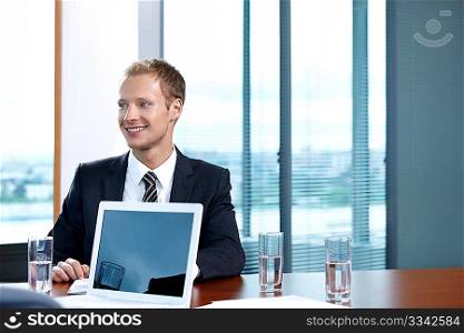 The young man in a suit with the laptop at office