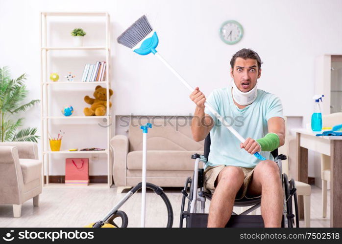 The young man in wheel-chair cleaning the house. Young man in wheel-chair cleaning the house