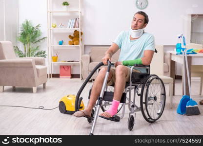 The young man in wheel-chair cleaning the house. Young man in wheel-chair cleaning the house