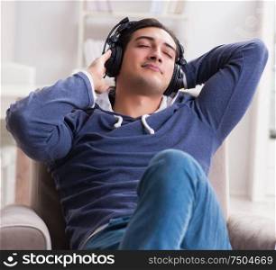 The young man listening to music at home. Young man listening to music at home