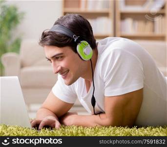 The young man listening to the music from laptop. Young man listening to the music from laptop