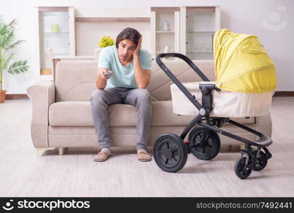 The young man looking after baby in pram. Young man looking after baby in pram