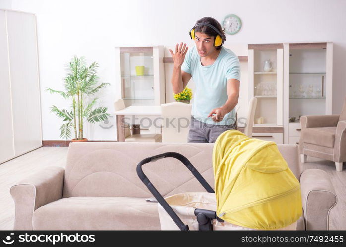 The young man looking after baby in pram. Young man looking after baby in pram