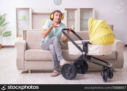 The young man looking after baby in pram. Young man looking after baby in pram