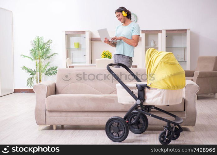 The young man looking after baby in pram. Young man looking after baby in pram