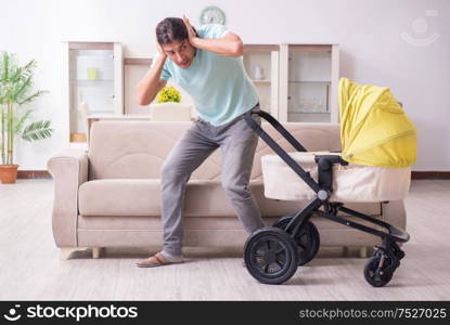 The young man looking after baby in pram. Young man looking after baby in pram