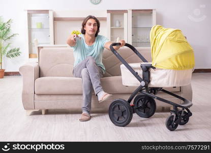 The young man looking after baby in pram. Young man looking after baby in pram