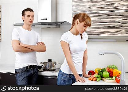 The young man looks at the girl on kitchen