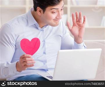 The young man making marriage proposal over internet laptop. Young man making marriage proposal over internet laptop