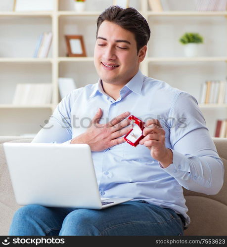 The young man making marriage proposal over internet laptop. Young man making marriage proposal over internet laptop