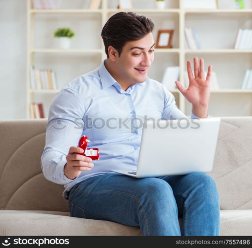 The young man making marriage proposal over internet laptop. Young man making marriage proposal over internet laptop