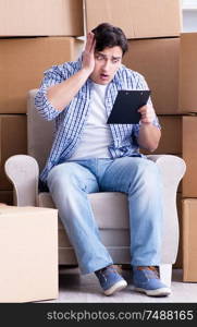 The young man moving in to new house with boxes. Young man moving in to new house with boxes