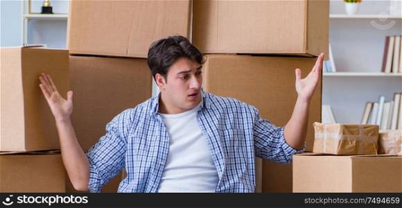 The young man moving in to new house with boxes. Young man moving in to new house with boxes