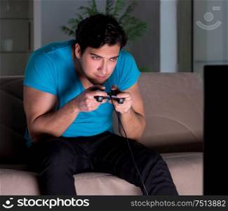 The young man playing computer games late at night. Young man playing computer games late at night