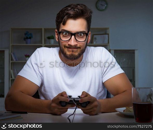 The young man playing games long hours late in the office. Young man playing games long hours late in the office