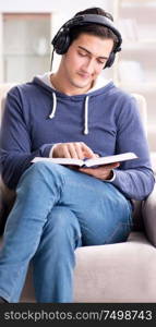 The young man reading book and listening to audio book. Young man reading book and listening to audio book