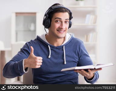 The young man reading book and listening to audio book. Young man reading book and listening to audio book