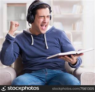 The young man reading book and listening to audio book. Young man reading book and listening to audio book