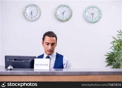 The young man receptionist at the hotel counter. Young man receptionist at the hotel counter