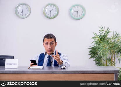 The young man receptionist at the hotel counter. Young man receptionist at the hotel counter