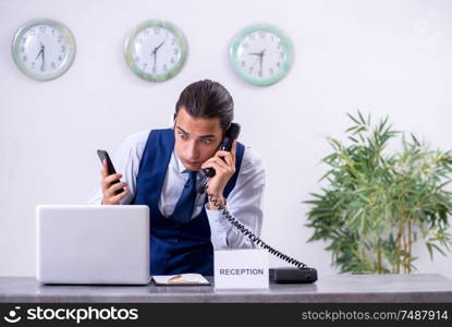 The young man receptionist at the hotel counter. Young man receptionist at the hotel counter