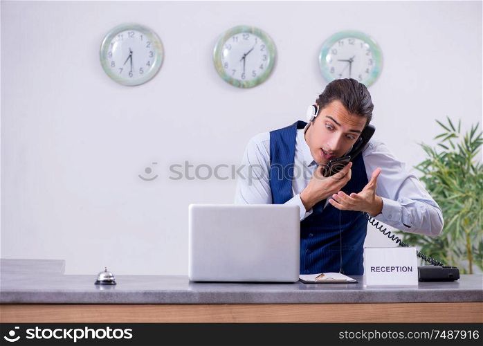The young man receptionist at the hotel counter. Young man receptionist at the hotel counter